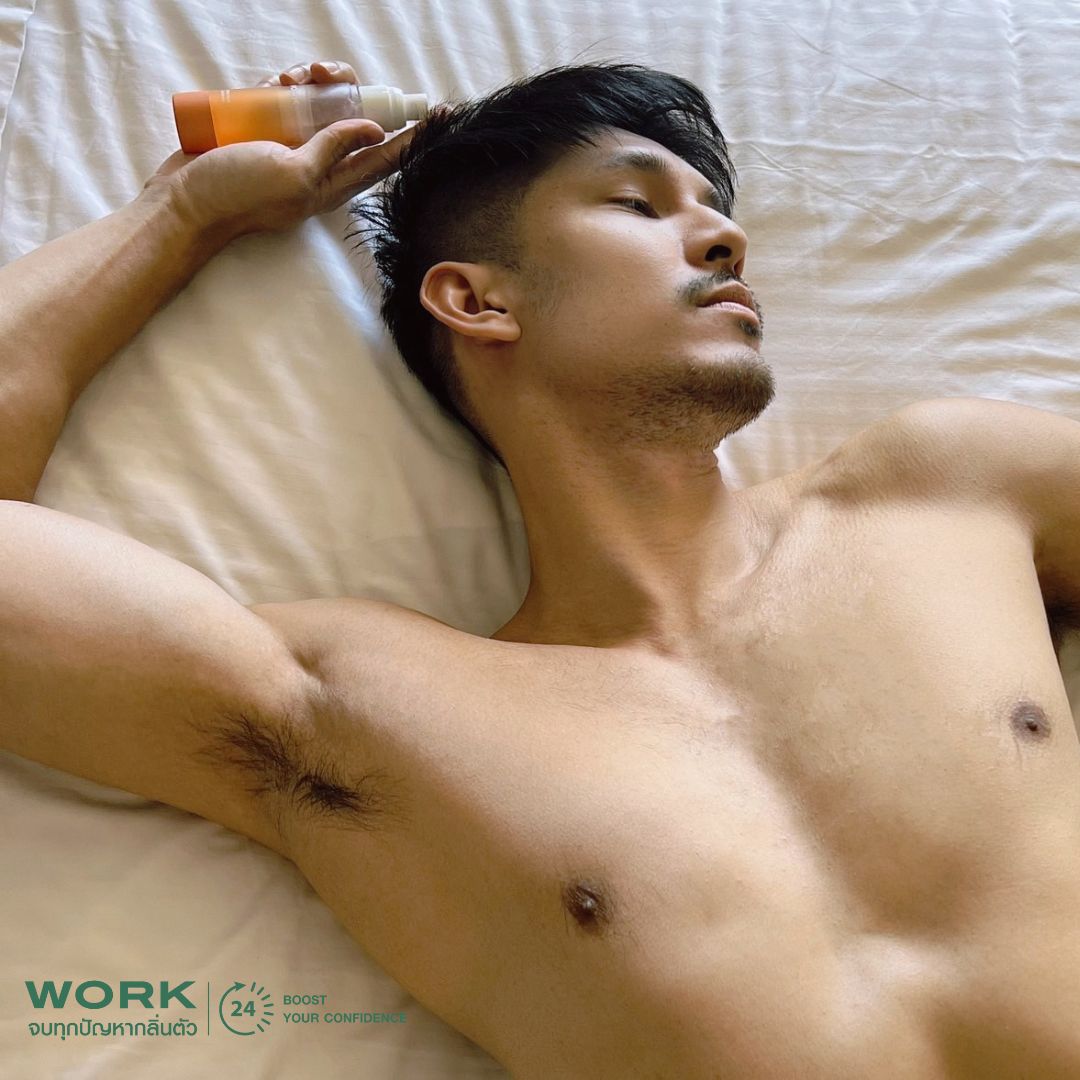 ผู้ชายนอนบนเตียงถือสเปรย์ระงับกลิ่นกาย WORK โชว์รักแร้